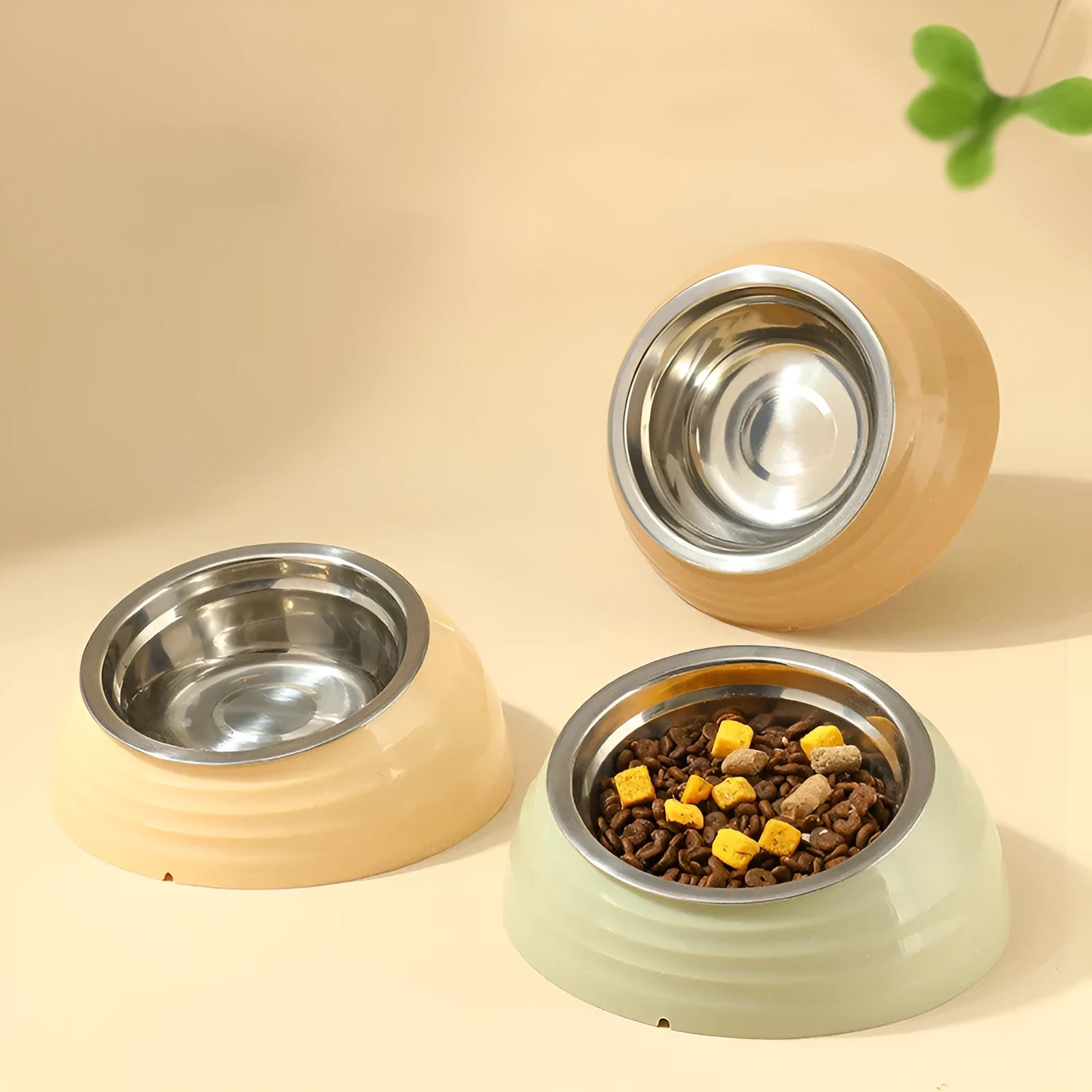 Stainless steel cat bowl in plastic base, available in light green, beige, and brown colours.