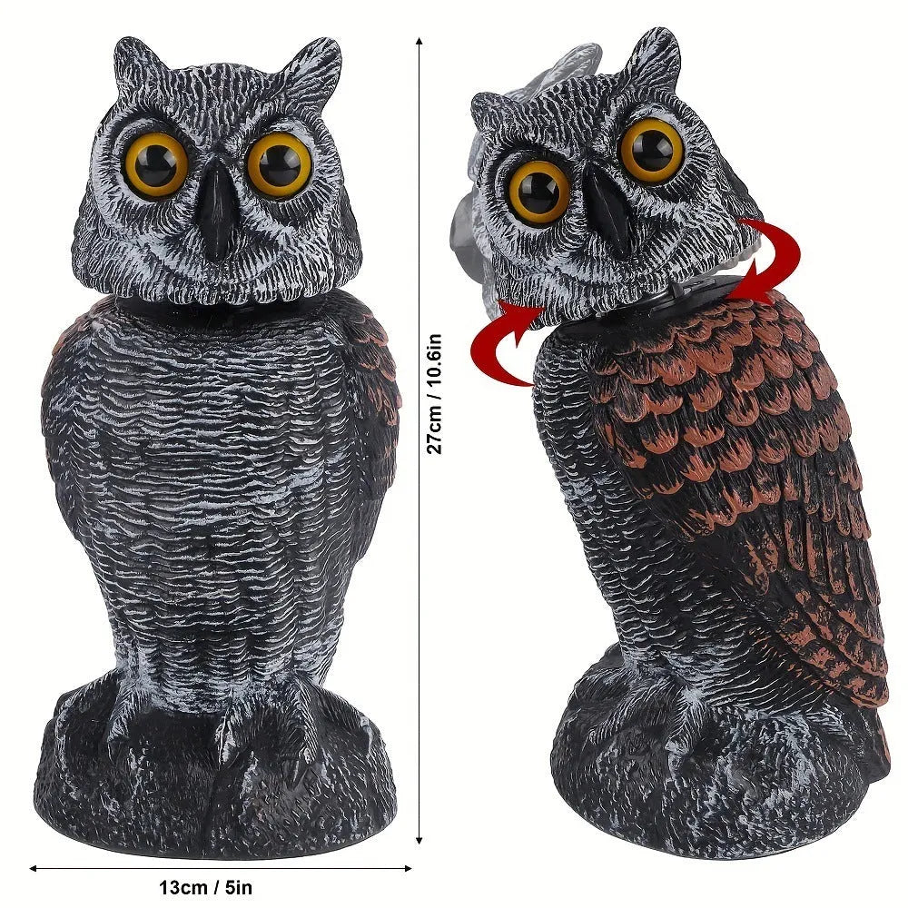Artificial owl bird scare decoy ornament with a shaking head, shown in a garden setting.