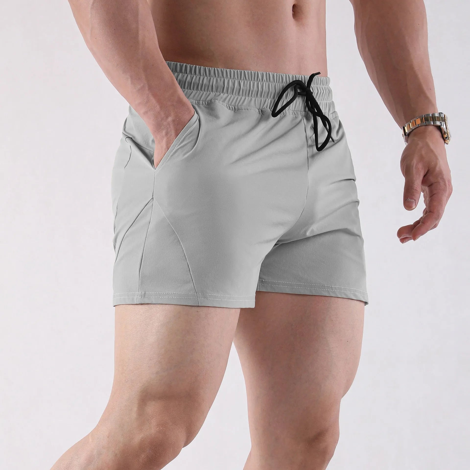 Men's thin grey polyester basketball shorts with an elastic waistband on a plain background.