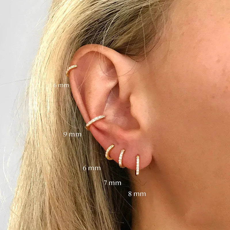 A pair of perforated geometric circle stud earrings with zircon details, shown in gold, rose gold, and silver colour options.