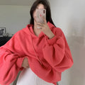 Watermelon red women's loose hooded sweater made from mulberry silk fabric on a hanger.