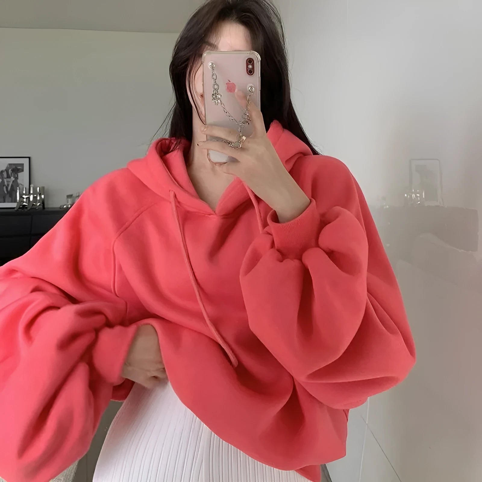Watermelon red women's loose hooded sweater made from mulberry silk fabric on a hanger.