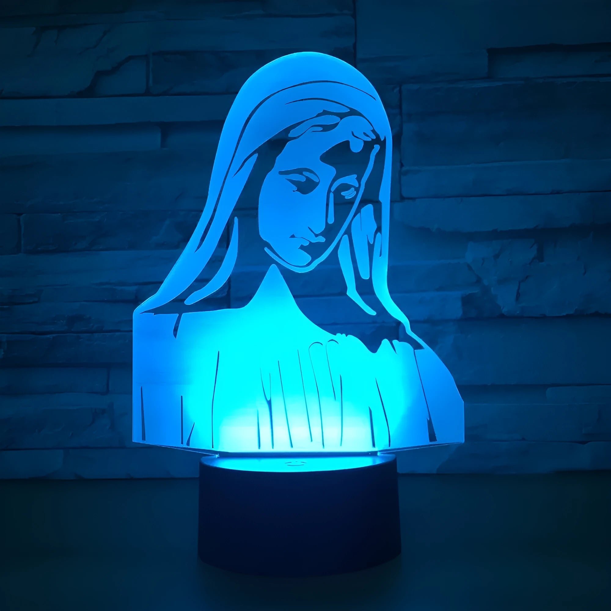 3D LED night light showing colourful dual ring pattern on acrylic panel, with remote control on desk.