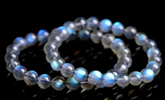 Natural blue moonlight crystal bracelet with smooth beads on a plain background.
