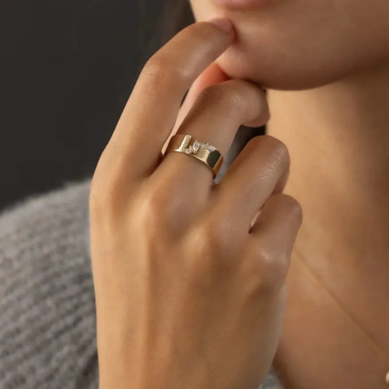 Gold electroplated women's ring with zircon detail on a copper band, showing sizing options.