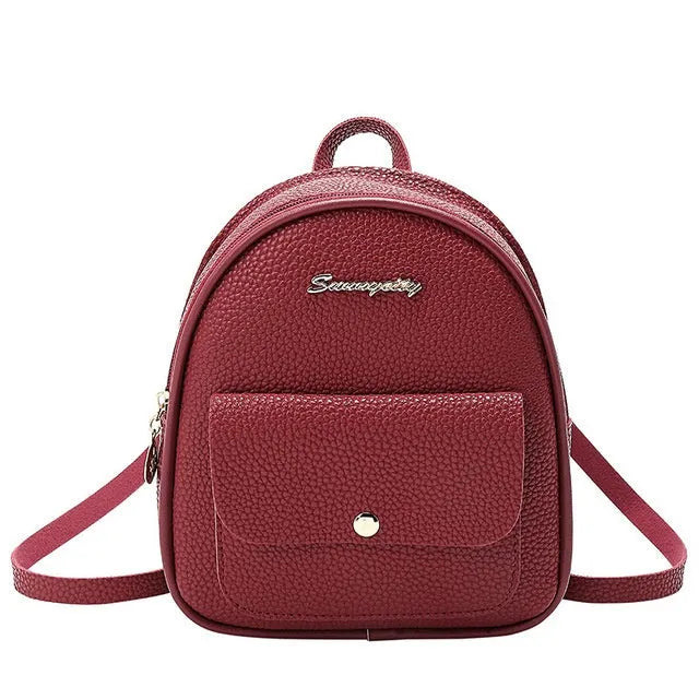 Small black PU leather ladies backpack with zipper, shown on shoulder