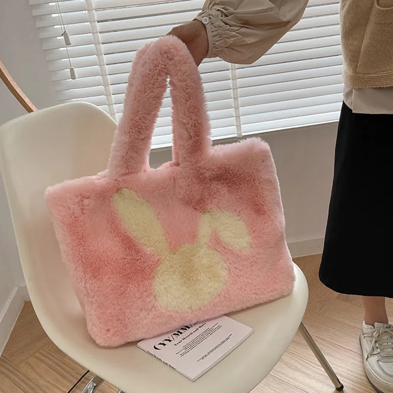Soft plush tote bag with cartoon rabbit ears on the front in a solid colour.