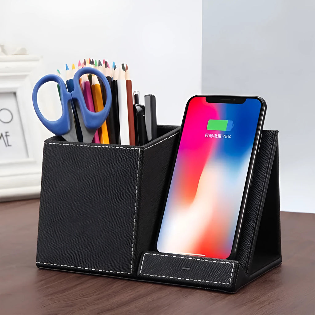 Black leather wireless charging station with built-in pen holder on a wooden desk.