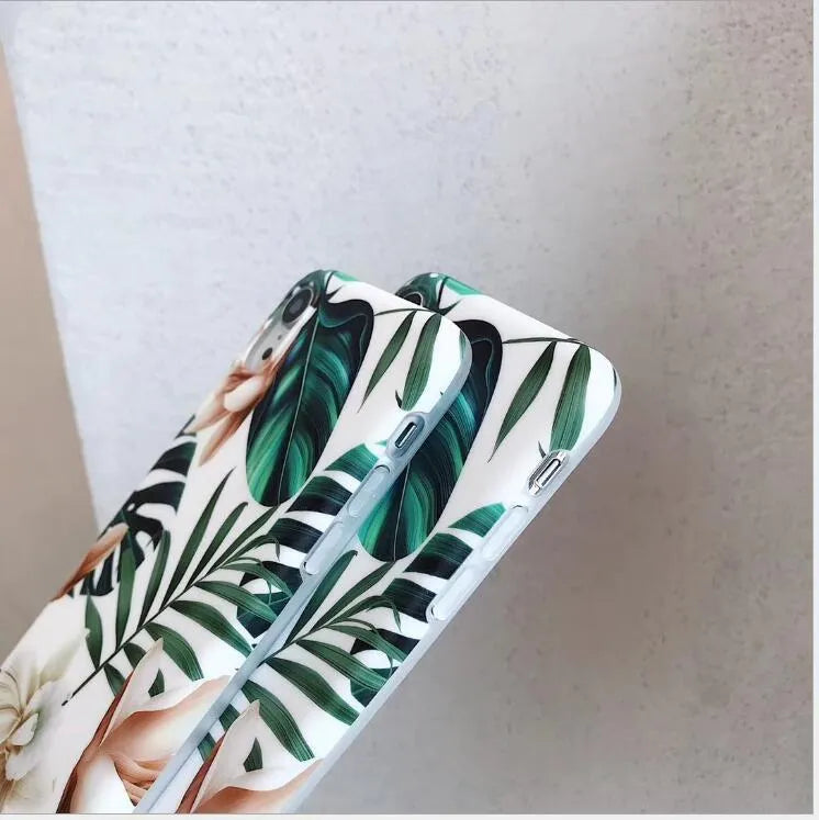 Soft TPU iPhone case with green banana leaf and pink floral art design on a white background.