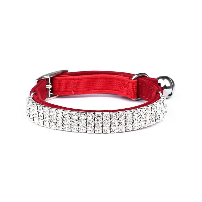 Close-up of a red suede velvet cat collar with rhinestones, showing the adjustable buckle.