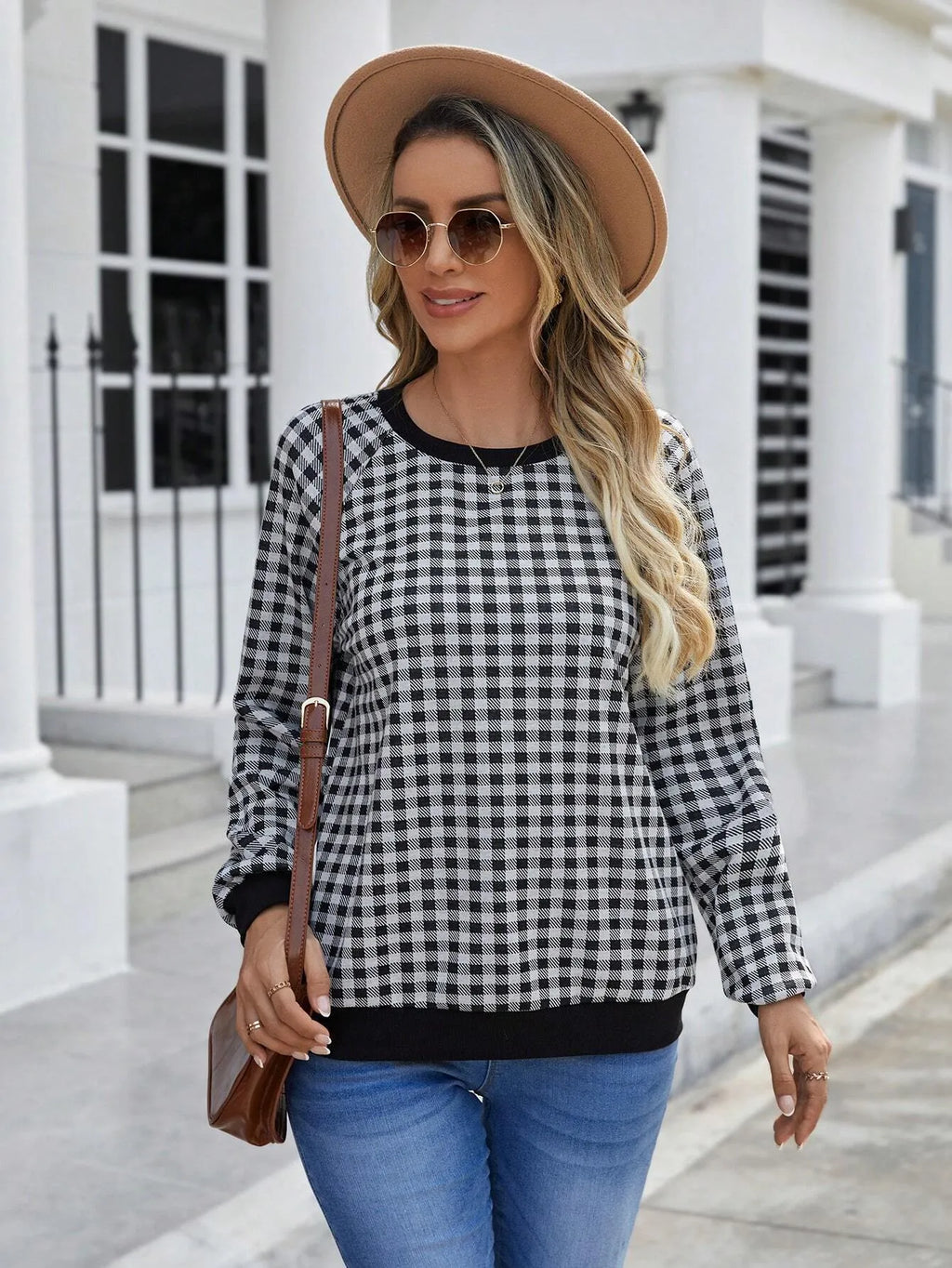 Black plaid print pullover sweater with long sleeves on mannequin
