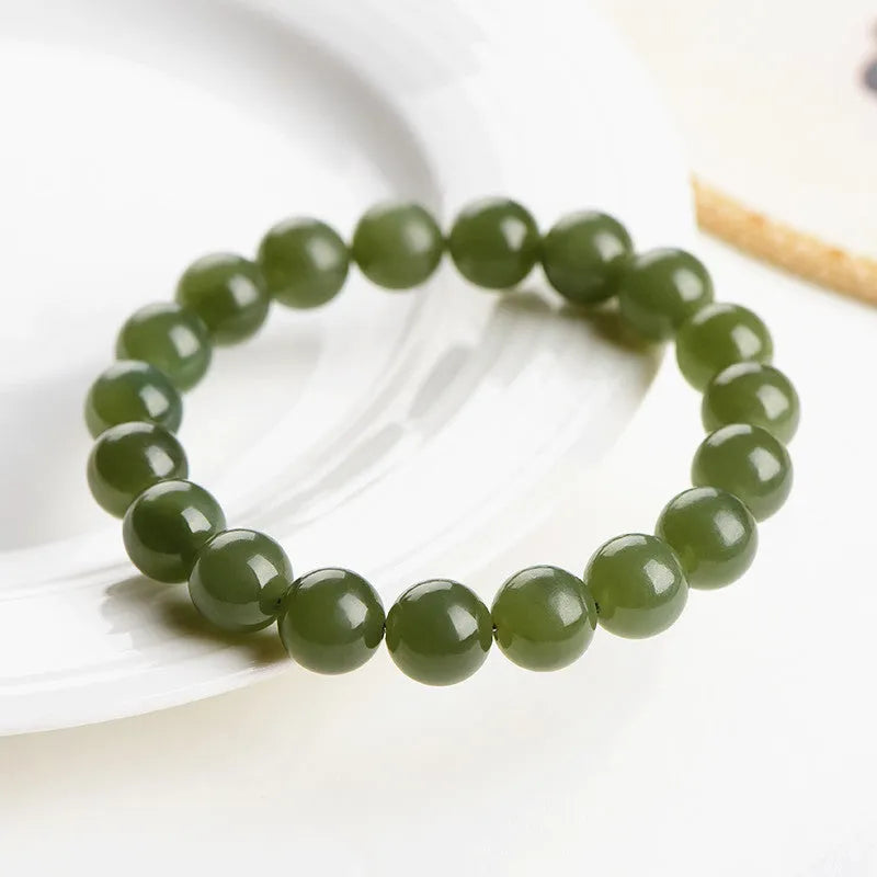 Polished Hetian jade ball bracelet in ice-like clear colour on a white background.