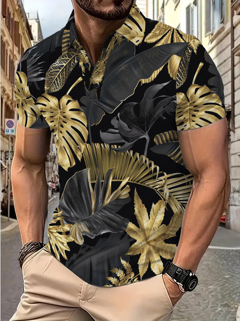 Man wearing a gold short sleeve shirt with a tropical leaf pattern print