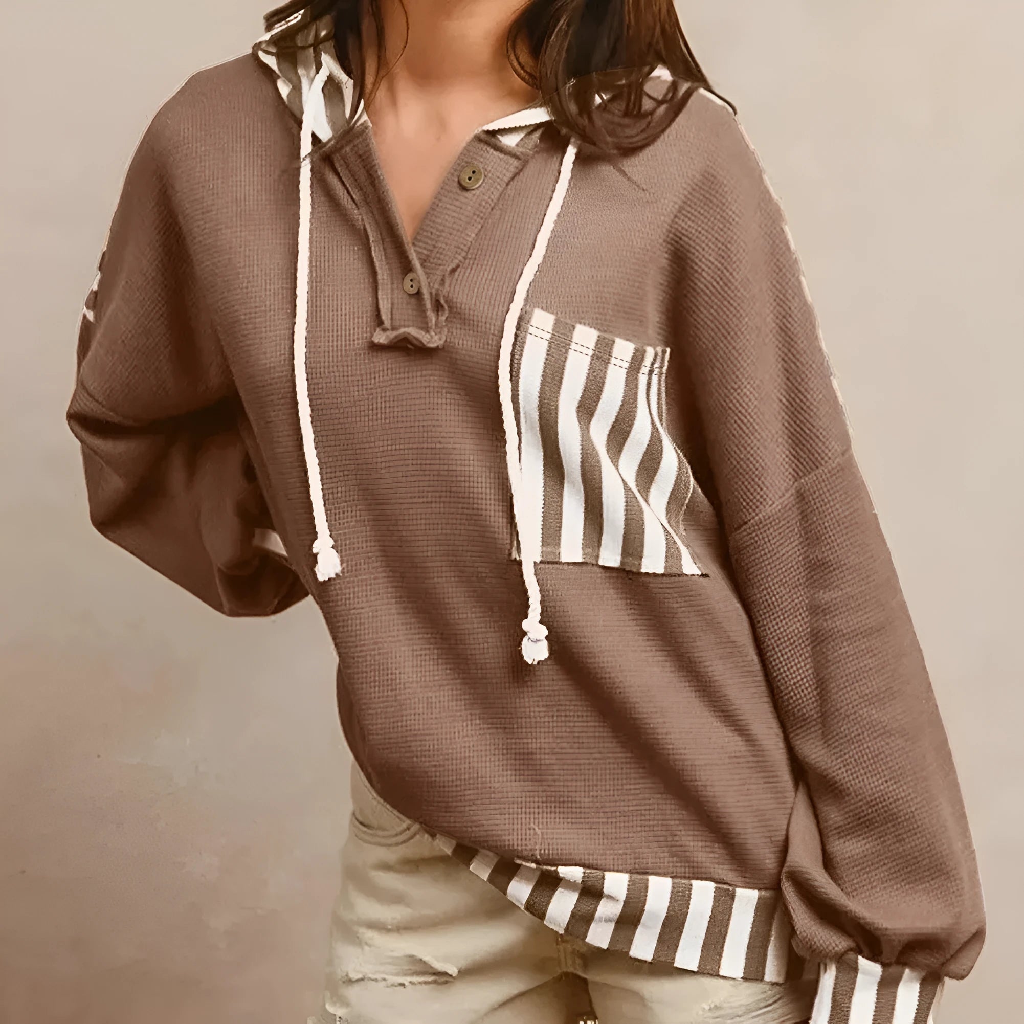 Straw yellow hoodie with waffle texture fabric and striped patchwork panels, featuring a drawstring hood and button neck.