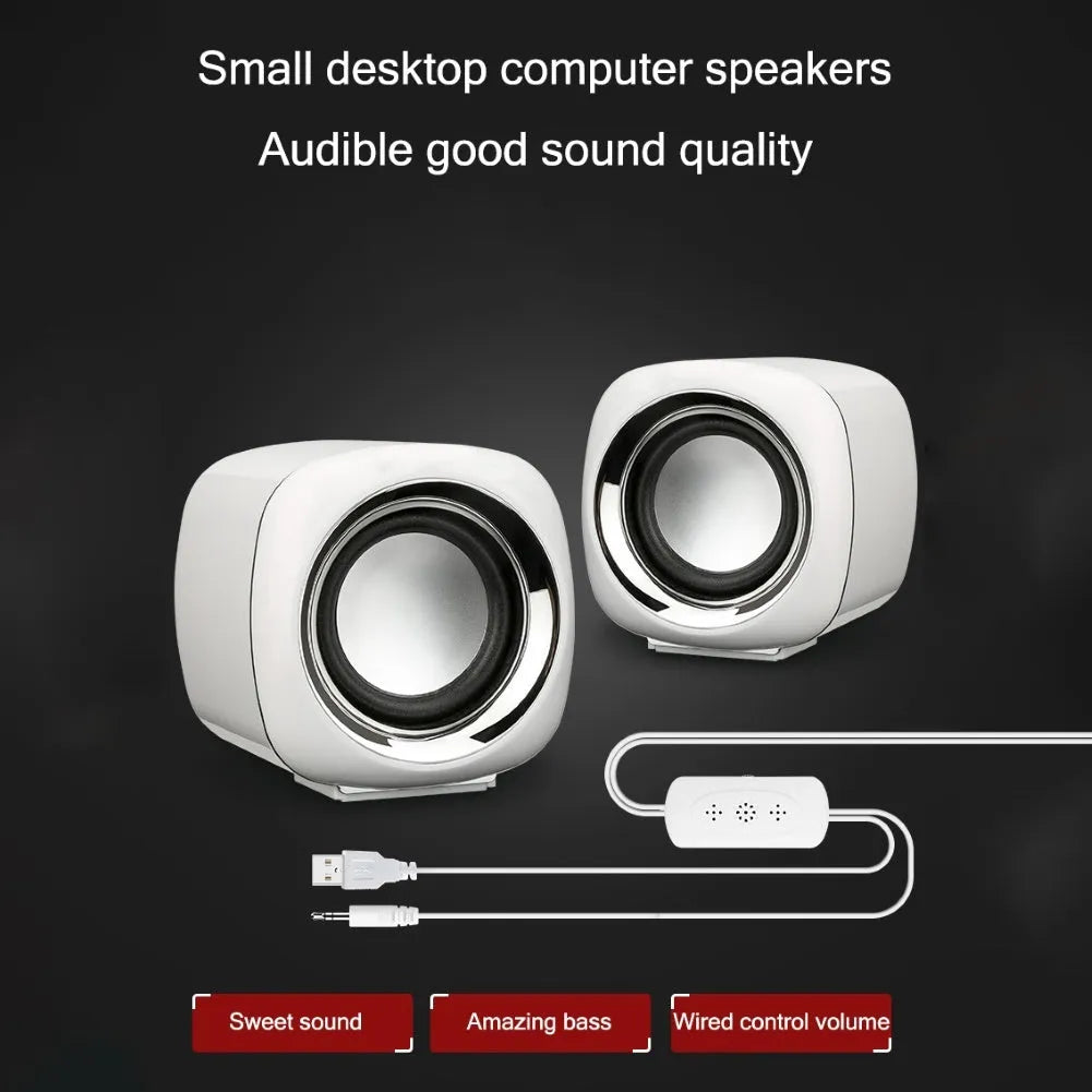A pair of compact black wired desktop computer speakers with a 3.5mm audio cable.