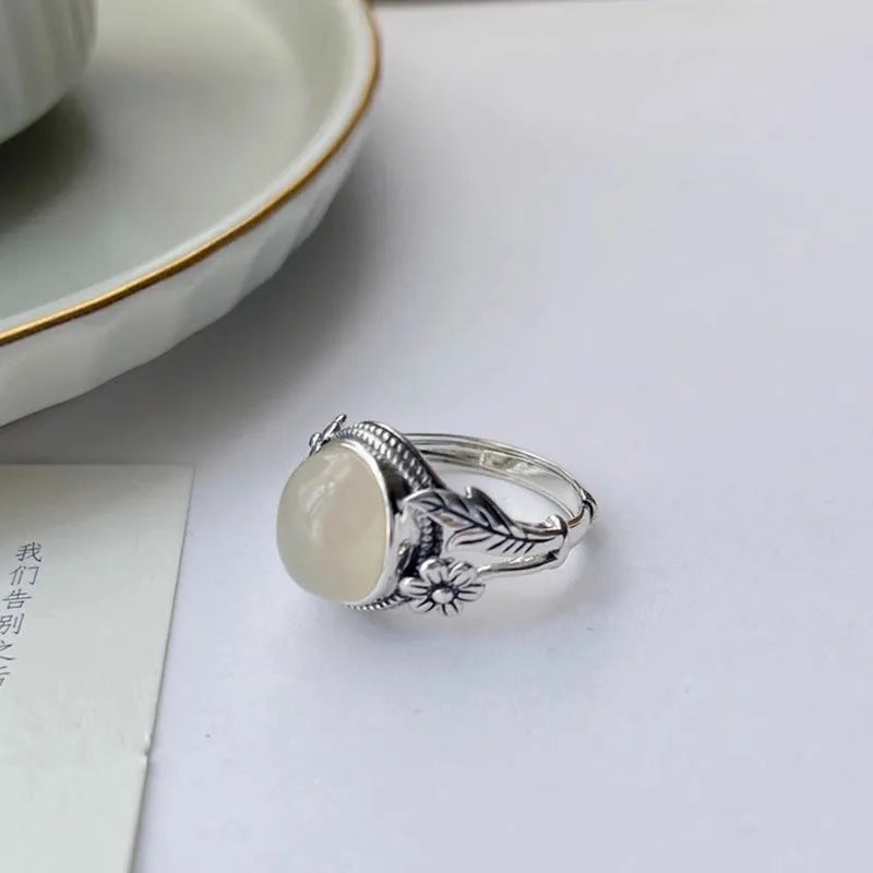 Adjustable vintage copper ring with a white imitation chalcedony stone on a U-shaped band.