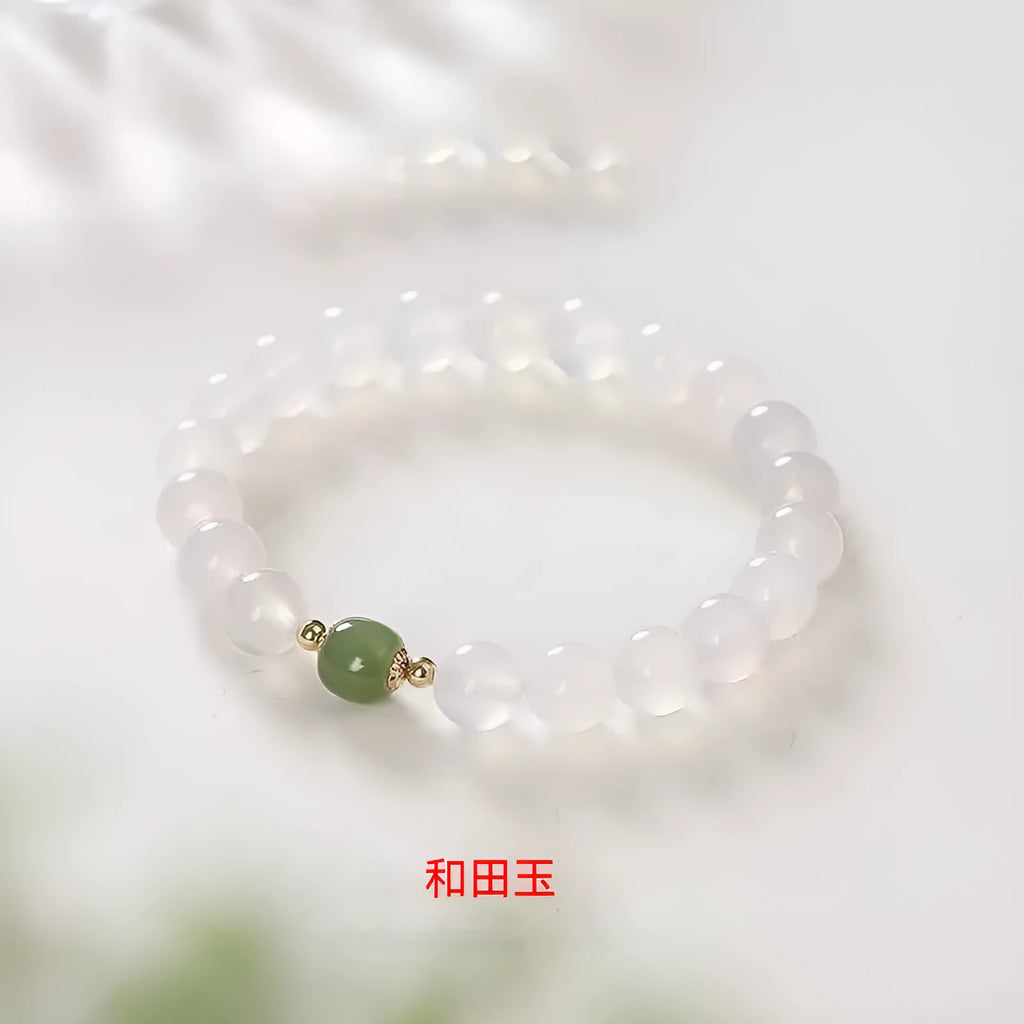 Handmade white agate and Hetian jade crystal bracelet with cinnabar accents on a wrist.