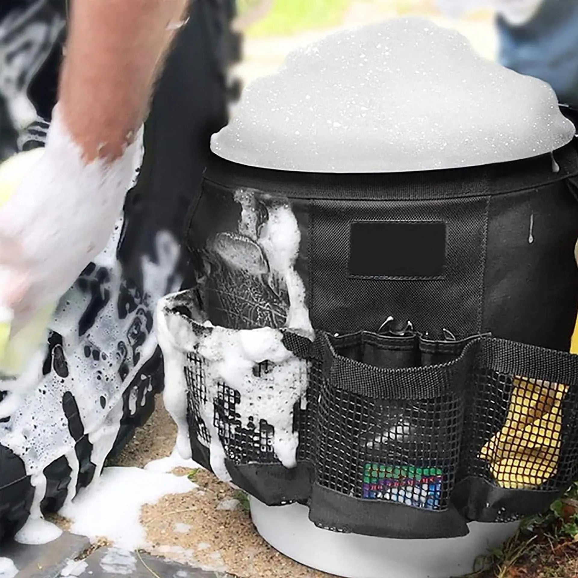Black cylindrical polyester storage bag hanging on a 5 gallon barrel with car washing tools inside