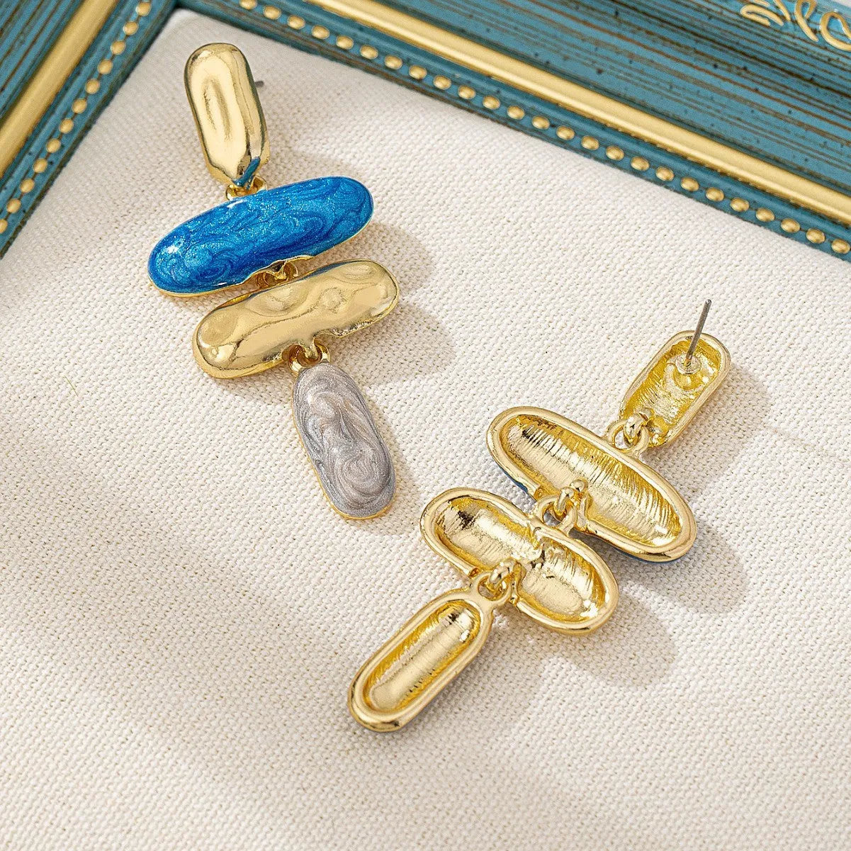 A pair of geometric stud earrings with a multicolour electroplated finish on a zinc alloy base.