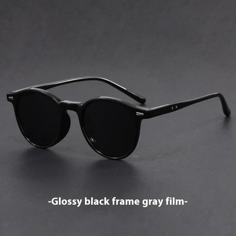 Retro round frame sunglasses with polarised grey lenses on a neutral background.