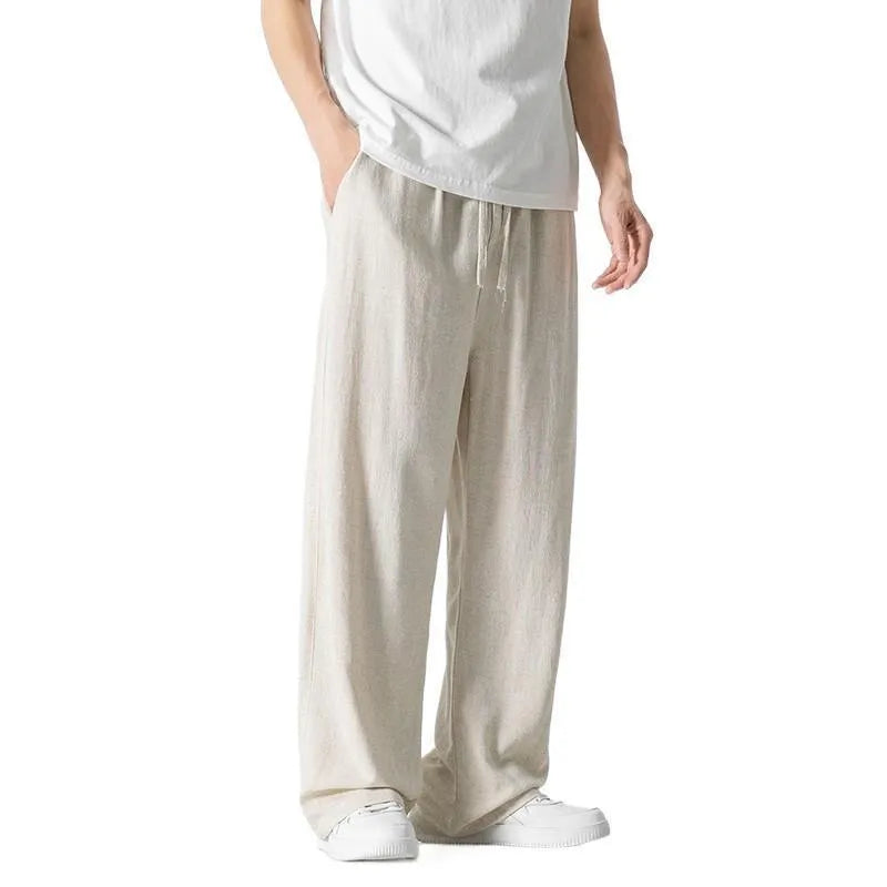 Man wearing beige straight-leg cropped linen trousers with a drawstring waist.