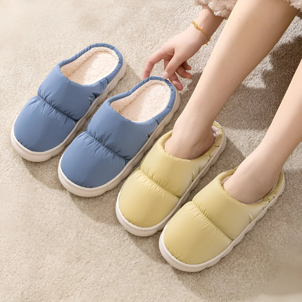 A pair of down cotton slippers with a thick rubber sole and artificial leather upper in a selected colour.