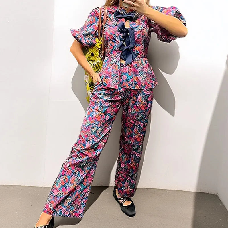 Women's floral print trouser suit co-ord set with puff sleeve top and matching trousers.