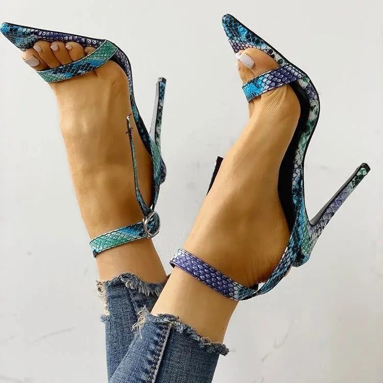Blue women's high heel shoe with buckle fastening and pointed toe on a white background.