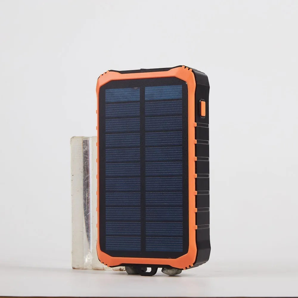 Green and orange portable solar hand crank power bank showing USB ports, solar panel, and hand crank