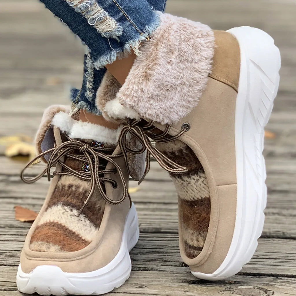 Women's beige lace-up snow boots with thermal lining and rubber sole on wooden surface