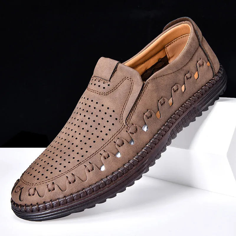 Men's brown leather slip-on casual shoes with flat sole, round toe, and decorative stitching.