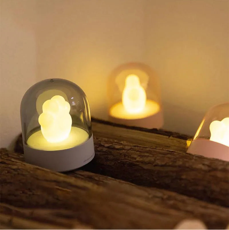 Grey and pink cat paw shaped USB rechargeable night light with music box function on desktop