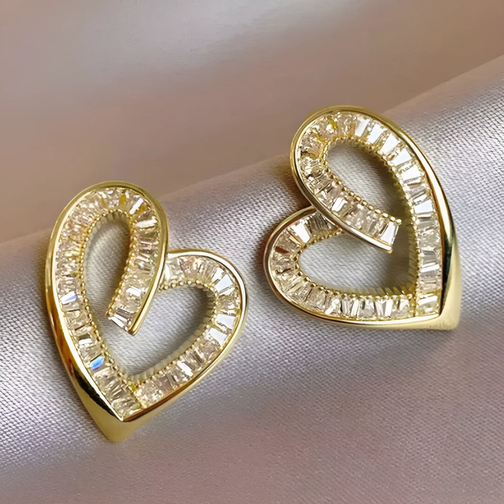 Hollowed heart shape ear studs in yellow gold tone copper with inlaid zircon detail