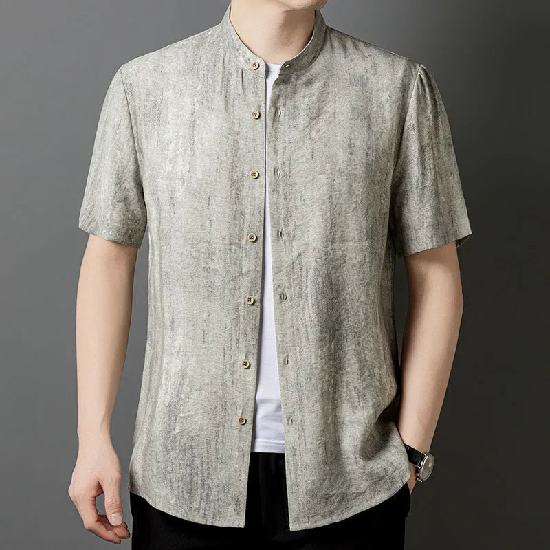 Man wearing a loose-fit black grey linen cardigan-style shirt with a stand collar and short sleeves.
