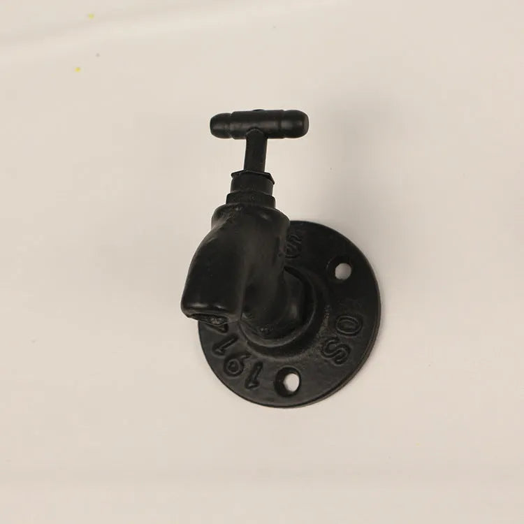 Metal water pipe style towel rack hook in modern design mounted on a wall.