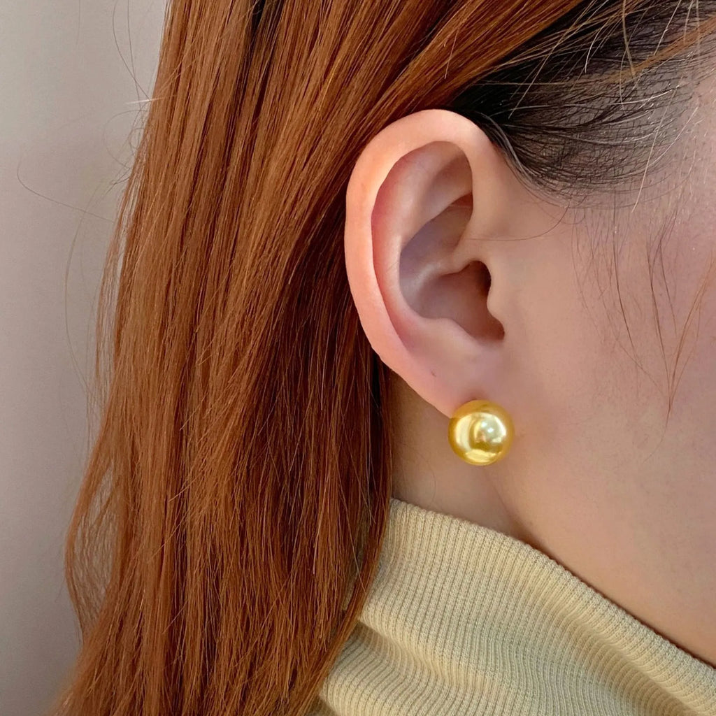 Close-up of retro-style geometric pearl stud earrings in silver, showing eight-awl star detail.
