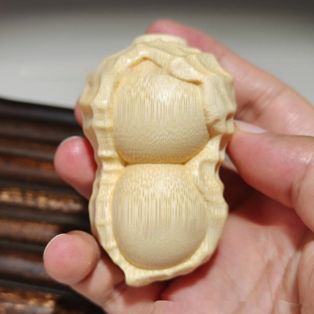 Solid bamboo peanut ornament carving on a plain background