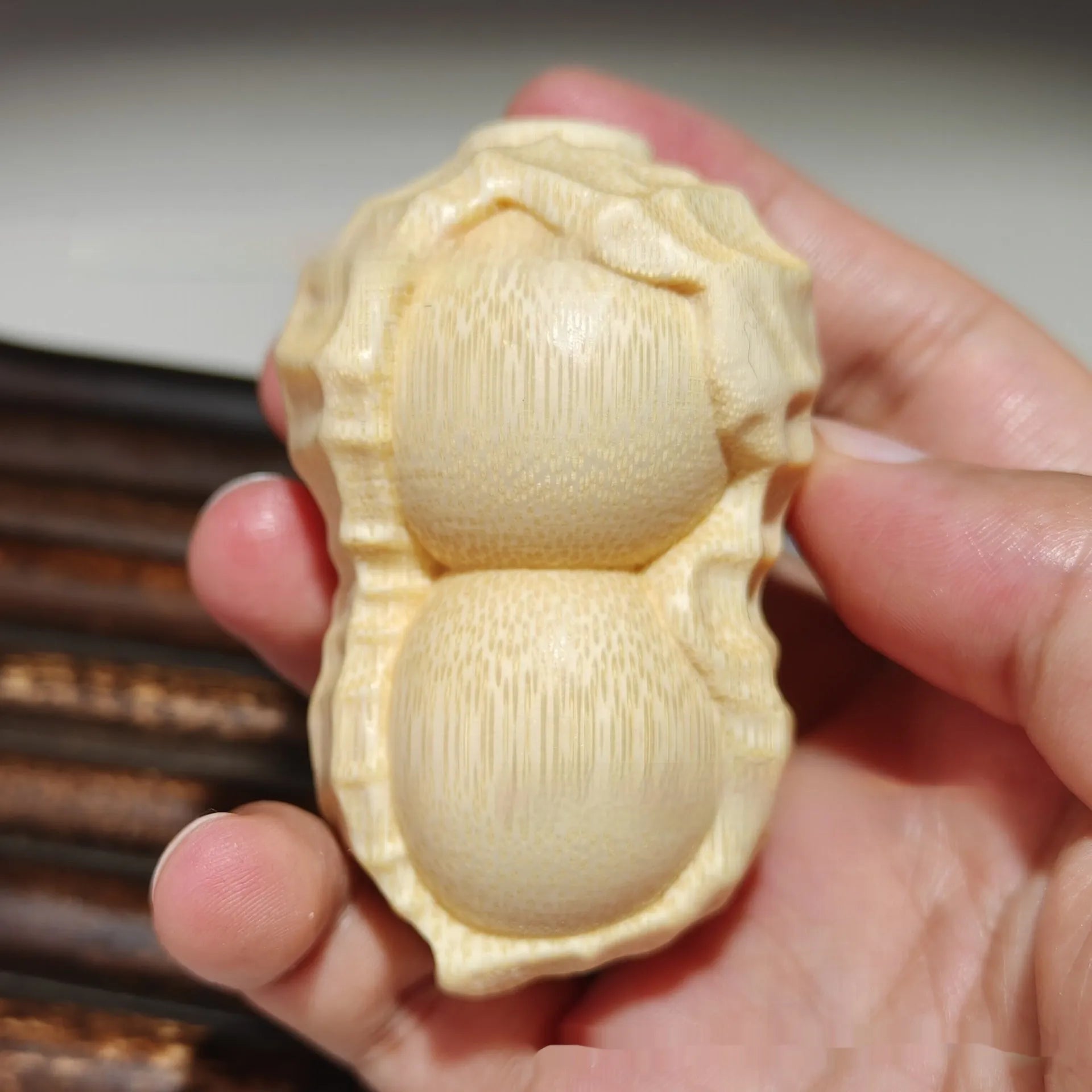 Solid bamboo peanut ornament carving on a plain background