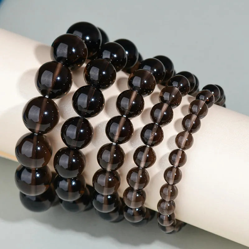 Adjustable sliding knot obsidian bracelet in hand with choice of black, rainbow eye, and silver crystal beads