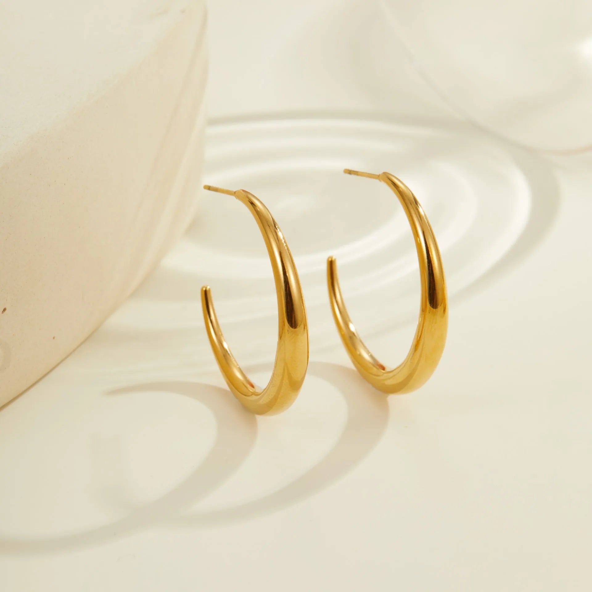 Titanium steel hoop earrings in geometric round design with gold and steel finish options