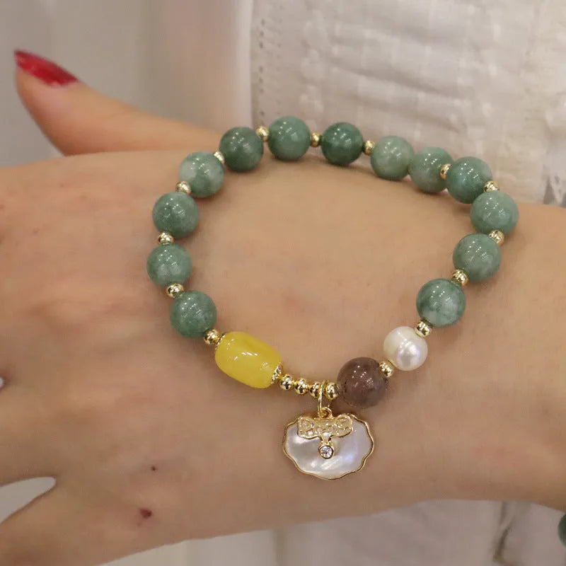 Green jade bracelet for women with a metal shell clasp on a wrist.