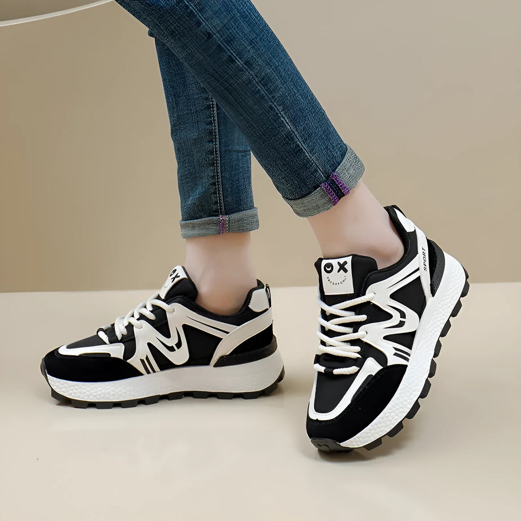Women's black platform casual sneakers with round toe and front lace-up, showing artificial PU upper and flat sole.