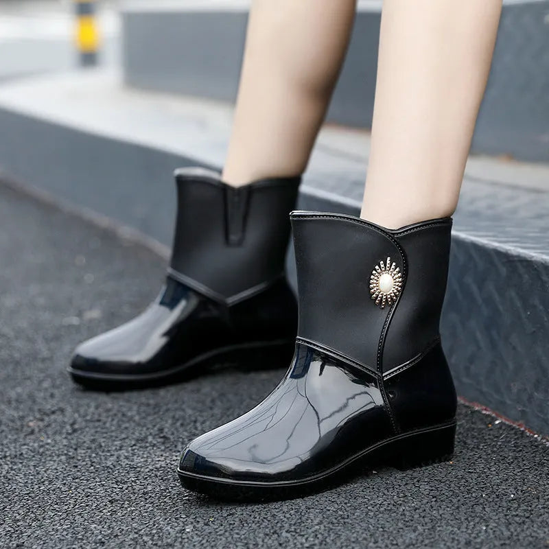 Women's purple PVC rain boots with a middle tube height and textured non-slip sole.
