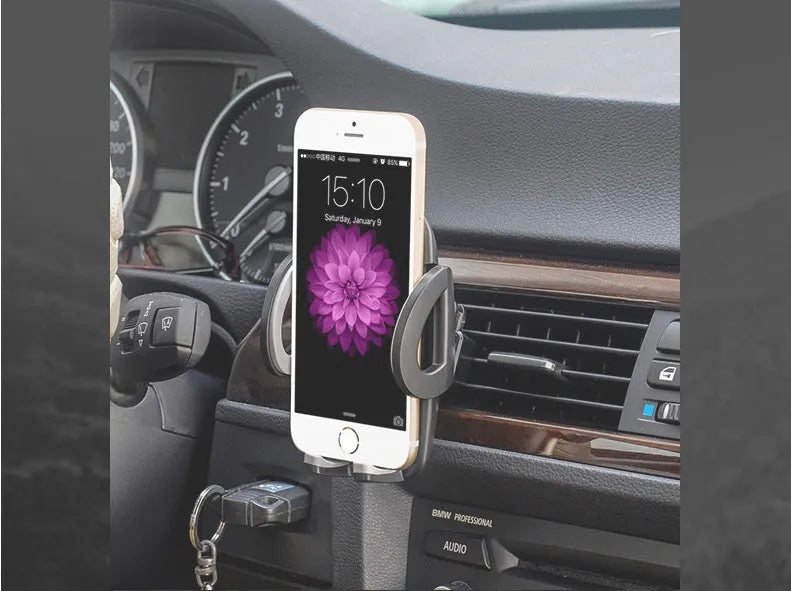Black plastic mobile phone holder attached to car air conditioning outlet for hands-free navigation