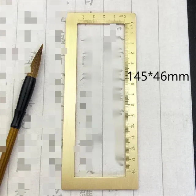 Square solid brass calligraphy paperweight with carved scale design on a wooden desk.
