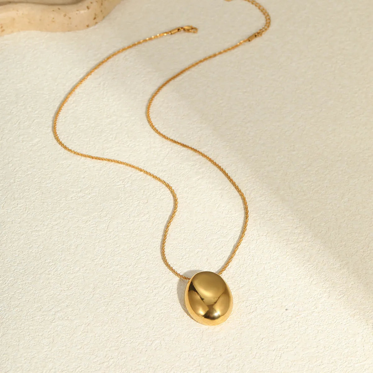 Gold-plated geometric pendant long necklace with adjustable chain on dark background