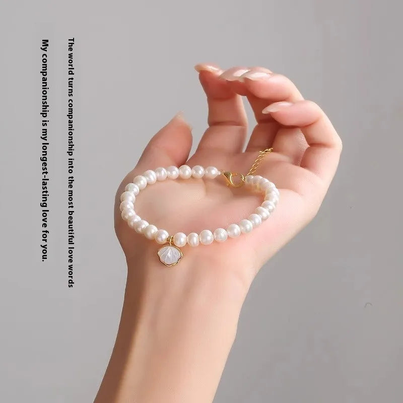 Women's fan-shaped freshwater pearl bracelet on wrist showing elastic string and extension chain options