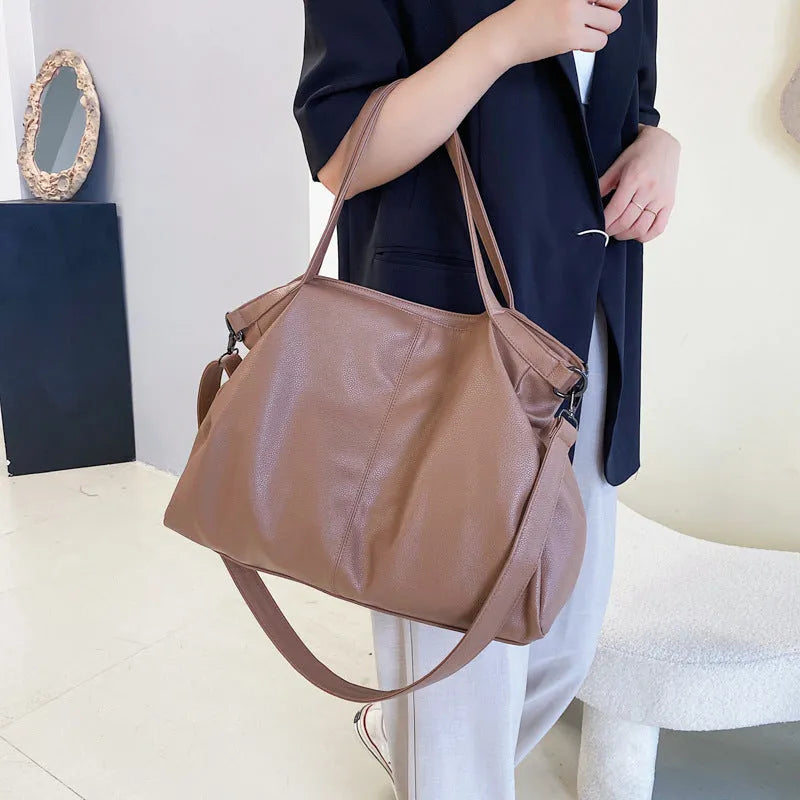 Large soft PU messenger bag in khaki colour with a long shoulder strap, shown open to reveal inner phone pocket.