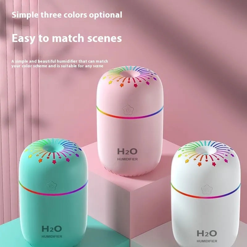 Small white, pink, or green USB-powered mini humidifier with water tank on a desk.