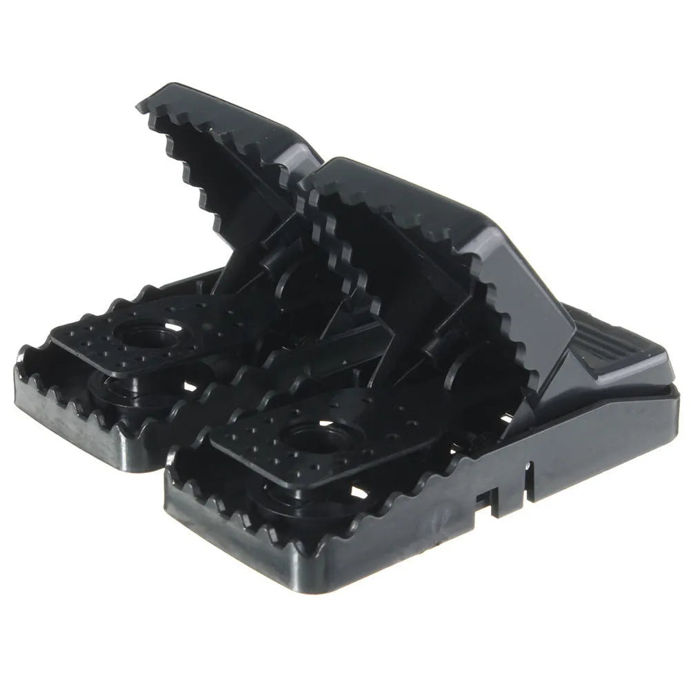 Six black plastic snapping mousetraps showing bite-trap mechanism with ruler showing 11cm length